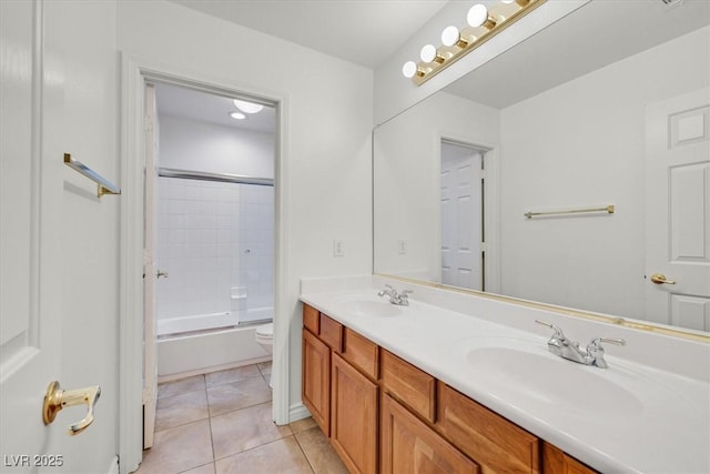 full bath with tile patterned floors, toilet, double vanity, and a sink