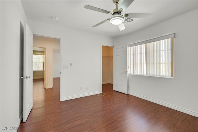 unfurnished bedroom with visible vents, ceiling fan, baseboards, and wood finished floors