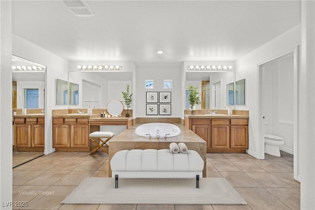 full bathroom featuring tile patterned flooring, a garden tub, visible vents, and a sink