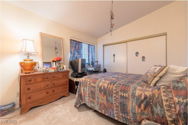 1892 Maricopa Dr, Laughlin, NV 89029 - bedroom featuring light carpet, a closet, vaulted ceiling, and a textured ceiling