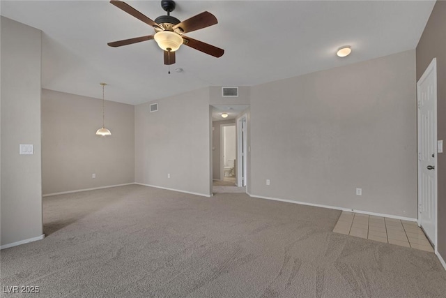 unfurnished room featuring carpet, visible vents, ceiling fan, and baseboards