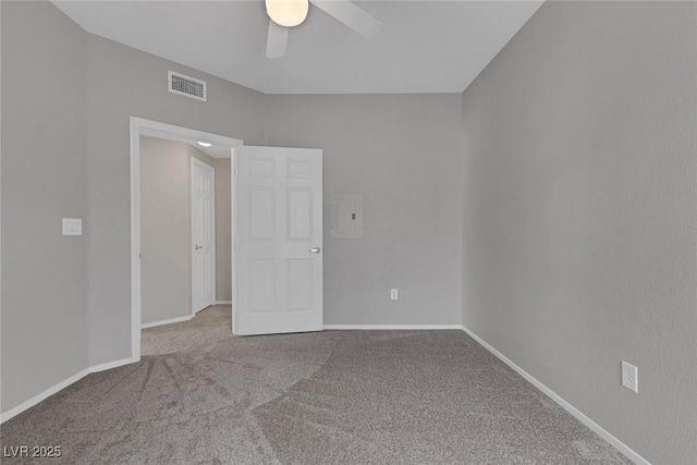 unfurnished room with carpet floors, a ceiling fan, visible vents, and baseboards