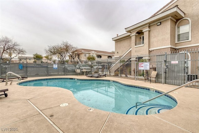 pool featuring fence and a patio