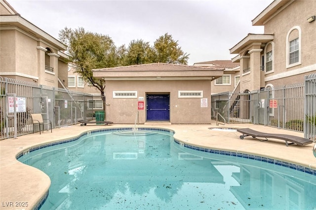 community pool featuring a patio area and fence