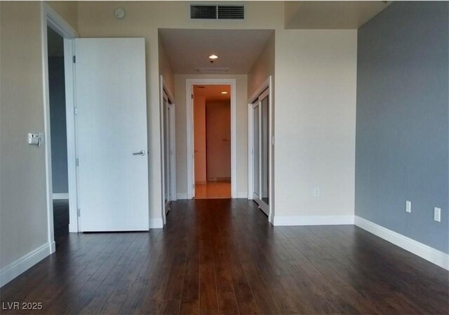 interior space featuring dark wood-style floors, recessed lighting, visible vents, and baseboards