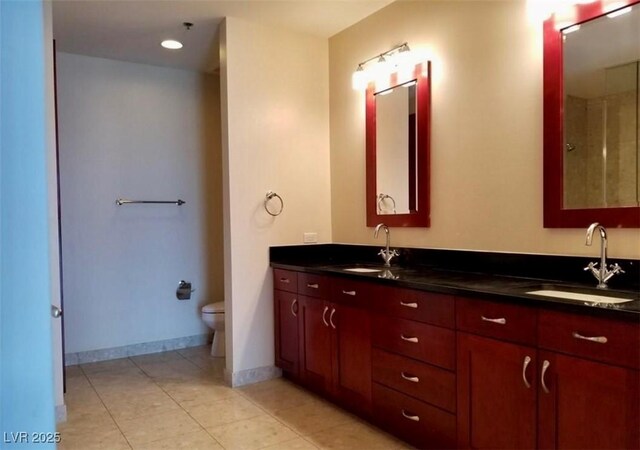 full bath with a sink, baseboards, and double vanity