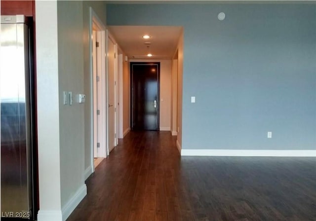 hall with dark wood-style floors, recessed lighting, and baseboards