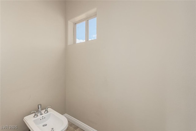 bathroom with baseboards, a bidet, and a sink