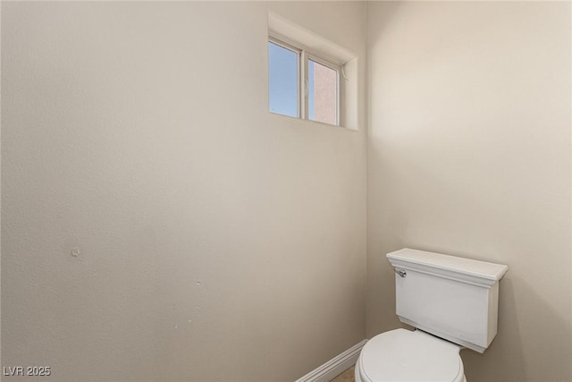 bathroom with baseboards and toilet