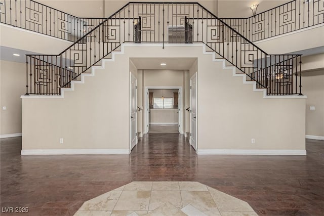 entrance foyer featuring stairway, recessed lighting, a towering ceiling, and baseboards