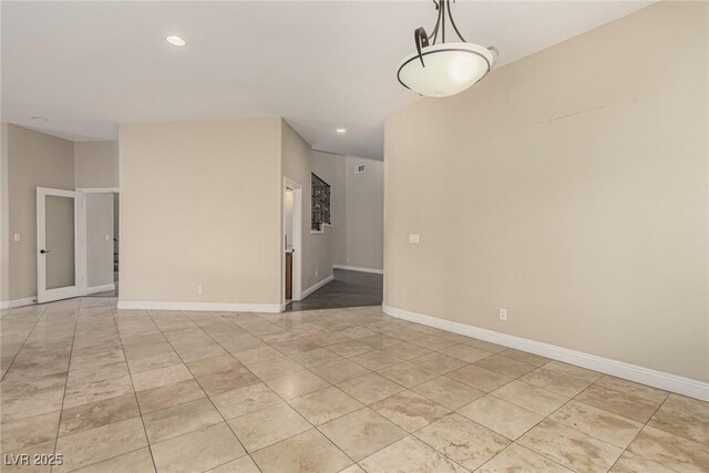 empty room featuring light tile patterned floors, recessed lighting, and baseboards