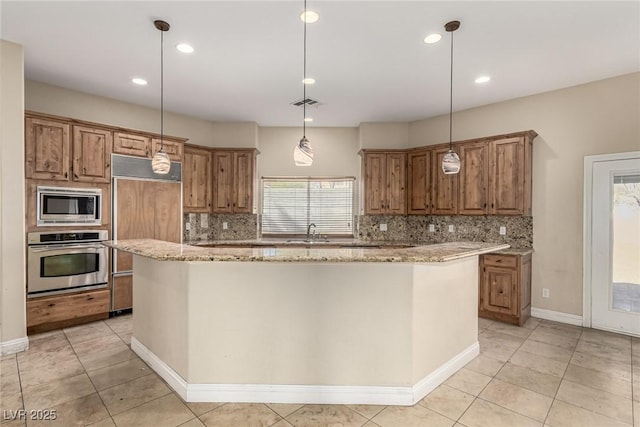 kitchen with visible vents, brown cabinetry, light stone counters, a center island, and built in appliances