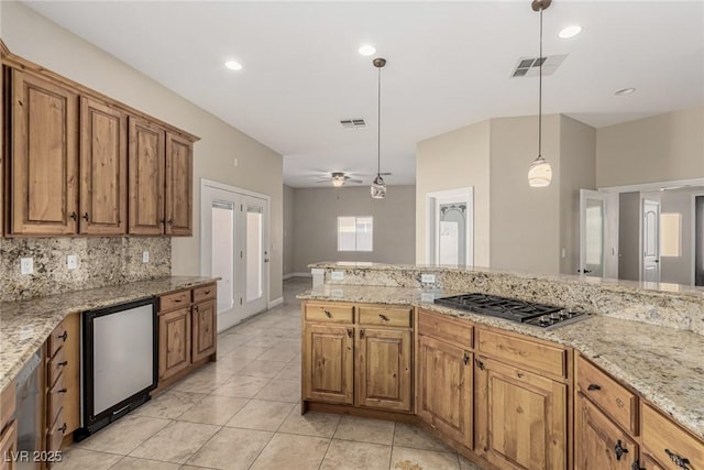 kitchen with visible vents, fridge, backsplash, decorative light fixtures, and stainless steel gas stovetop