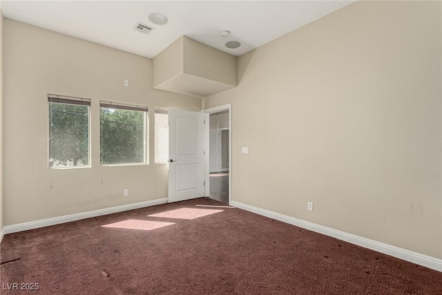 unfurnished room featuring carpet floors, visible vents, and baseboards