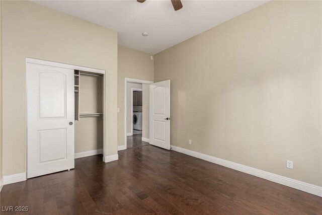 unfurnished bedroom featuring dark wood-style floors, washer / clothes dryer, a closet, and baseboards