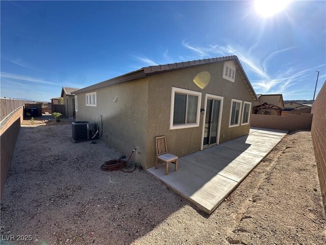 back of property with a patio area, a fenced backyard, cooling unit, and stucco siding