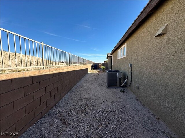 view of property exterior featuring central AC, a fenced backyard, and stucco siding