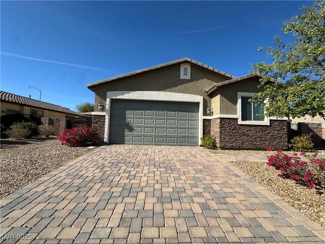 ranch-style home with an attached garage, a tile roof, stone siding, decorative driveway, and stucco siding