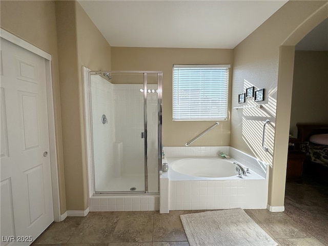 bathroom featuring a stall shower, baseboards, and a bath