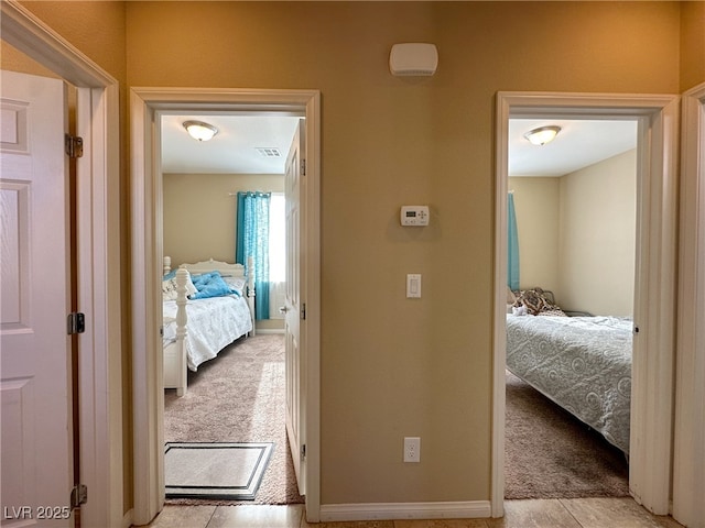 corridor featuring light carpet and visible vents