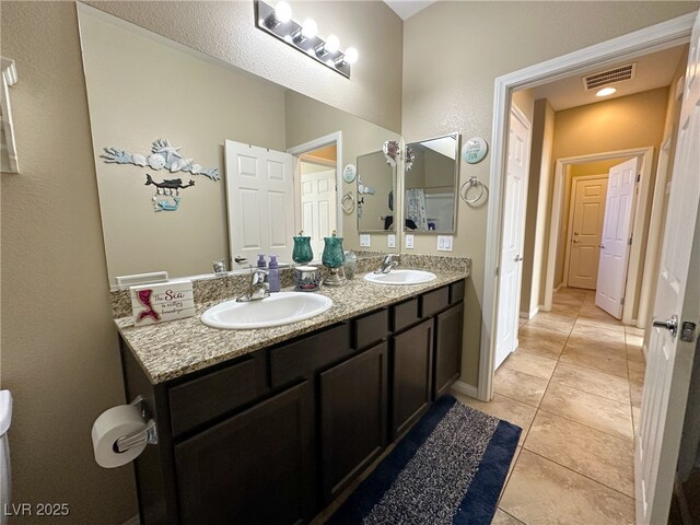 full bath featuring visible vents, a sink, baseboards, and double vanity