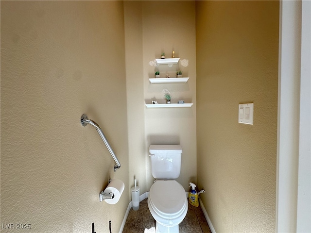 bathroom with toilet and baseboards