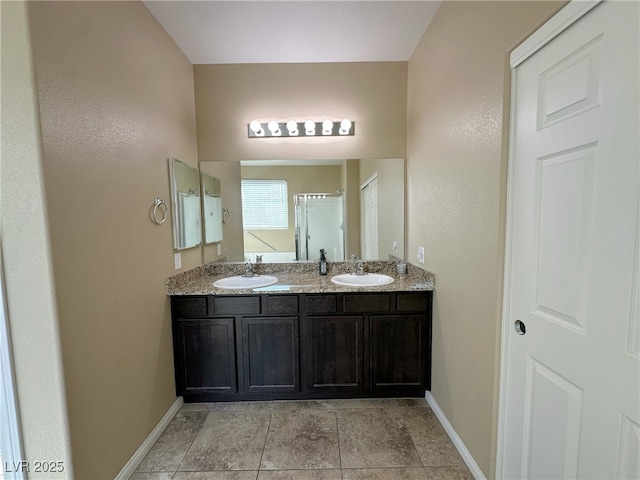 full bath featuring double vanity, baseboards, and a sink