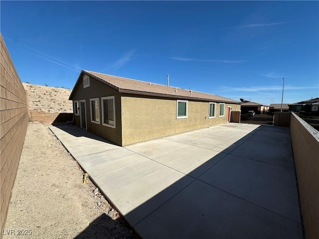 view of property exterior with a patio area, a fenced backyard, and stucco siding