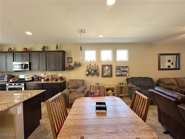 dining room with light tile patterned floors, a textured ceiling, visible vents, and recessed lighting