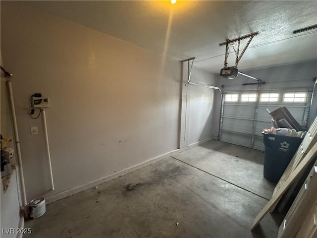 garage featuring a garage door opener and baseboards