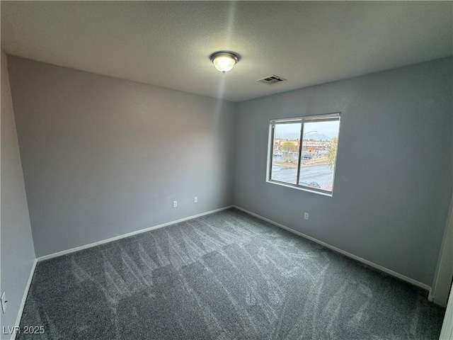 empty room featuring visible vents, a textured ceiling, baseboards, and carpet floors