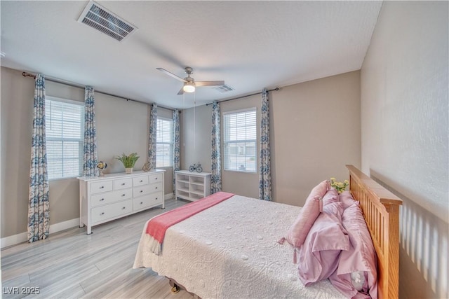 bedroom featuring baseboards, visible vents, ceiling fan, and light wood finished floors