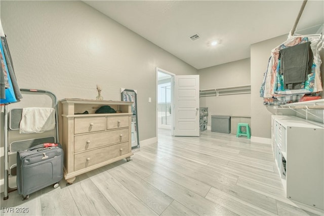 laundry area with light wood-style floors, visible vents, and baseboards