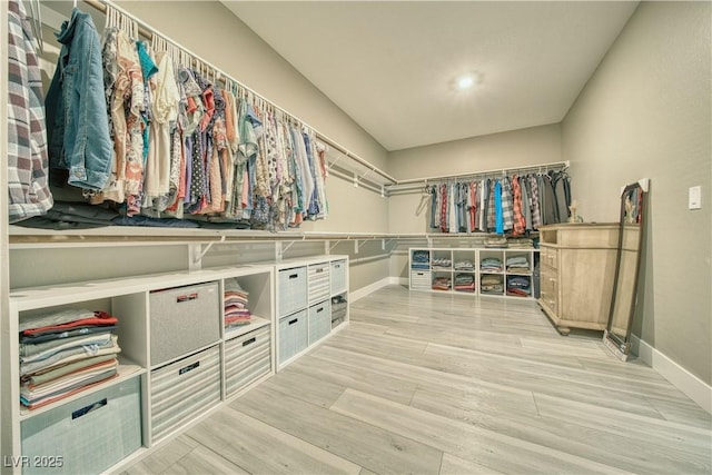 walk in closet with light wood-style floors