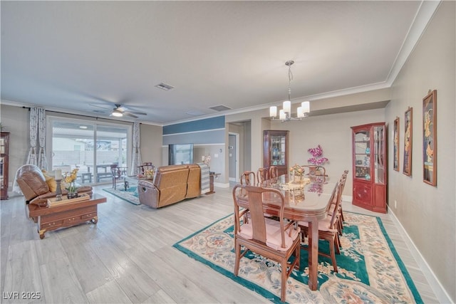 dining area featuring visible vents, ornamental molding, and light wood-style flooring