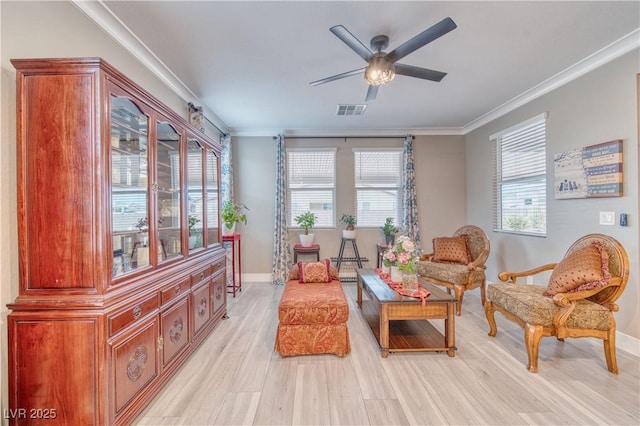 sitting room featuring ornamental molding, light wood-type flooring, visible vents, and ceiling fan