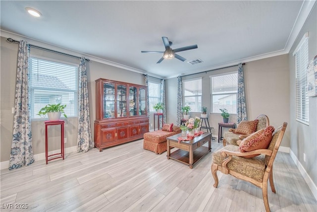 living area with crown molding, light wood finished floors, visible vents, ceiling fan, and baseboards