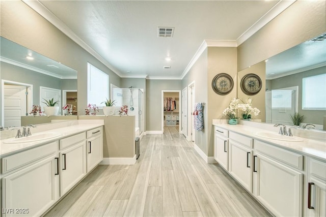 bathroom featuring a stall shower, visible vents, a sink, and wood finished floors