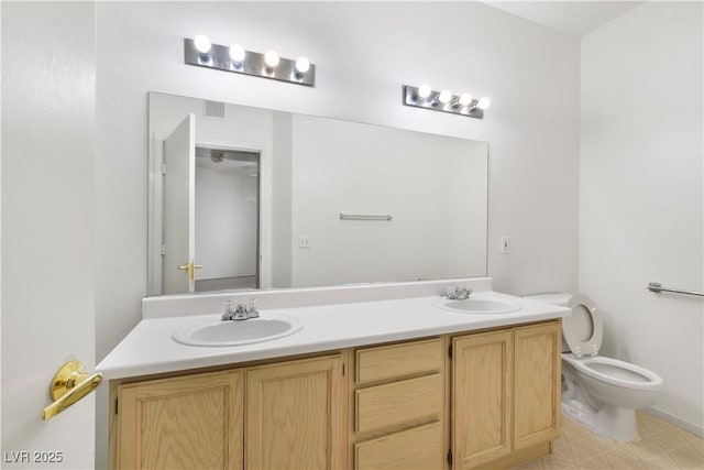 full bath with visible vents, double vanity, a sink, and toilet