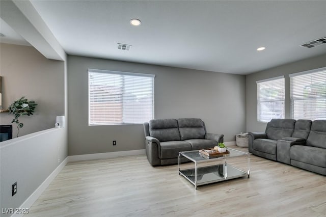 living area featuring wood finished floors, baseboards, and recessed lighting
