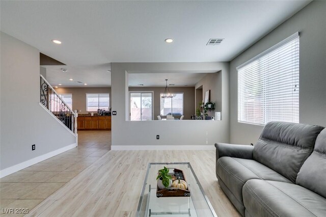 living room with recessed lighting, baseboards, stairway, light wood-type flooring, and a chandelier