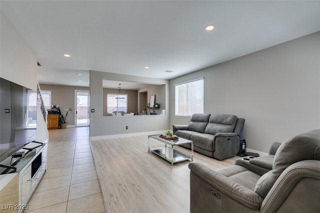 living room with a chandelier, recessed lighting, baseboards, and light wood-style floors