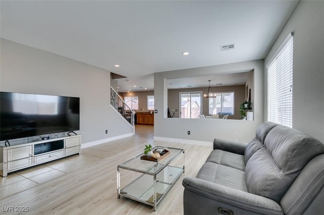 living area featuring stairway, a chandelier, baseboards, recessed lighting, and light wood-type flooring