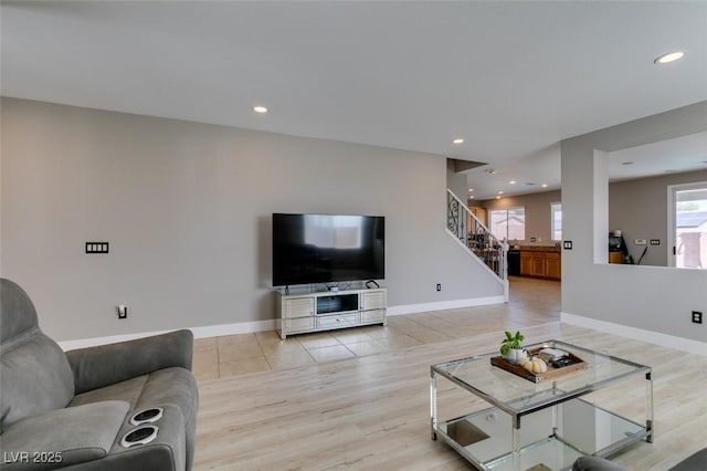 living area with stairway, baseboards, light wood finished floors, and recessed lighting