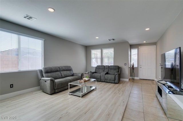 living area with recessed lighting, baseboards, and light wood-type flooring