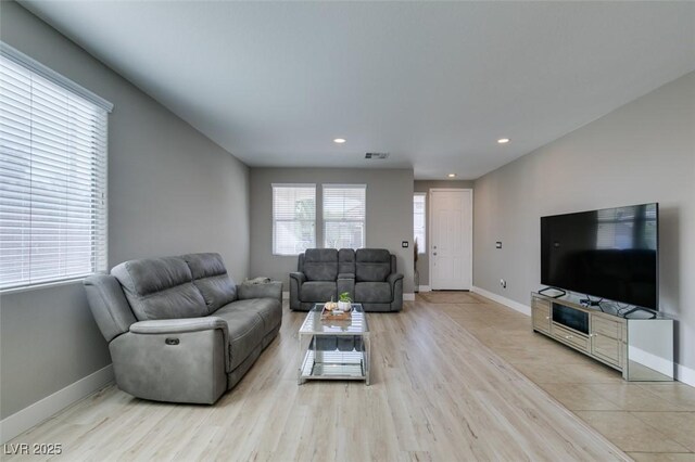 living room featuring recessed lighting, light wood-type flooring, visible vents, and baseboards