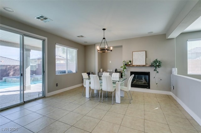 unfurnished dining area featuring light tile patterned floors, an inviting chandelier, visible vents, and baseboards