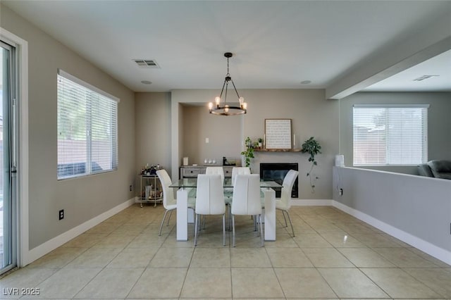 dining area featuring visible vents, a chandelier, baseboards, and light tile patterned flooring