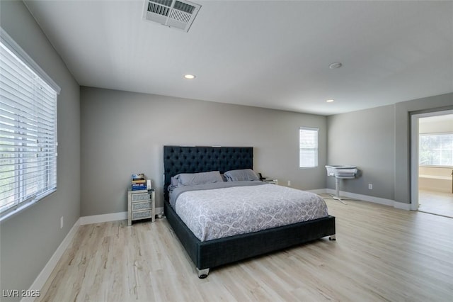 bedroom with baseboards, visible vents, light wood finished floors, and multiple windows