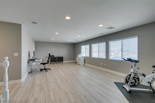 exercise room featuring wood finished floors, recessed lighting, and baseboards